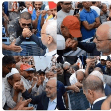 a group of men are standing in a crowd and one of them is wearing a ny hat