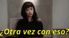 a woman is sitting at a desk with the words otra vez con eso written in yellow