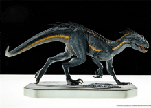 a statue of a black and yellow dinosaur is on a white surface