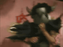 a person in a devil costume is holding another person in their arms