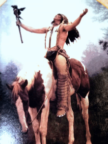 a man is riding a brown and white horse while holding a stick