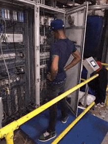 a man is standing in front of a electrical panel in a room .