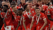 a group of soccer players are posing for a picture with medals around their necks and one of them has the number 19 on his jersey