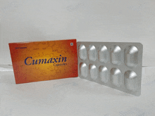 a box of cumaxin capsules sits on a white surface