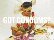 a woman is sitting at a table with condoms on it and the words got condoms above her