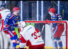 a hockey player with the number 33 on his back stands in front of the net