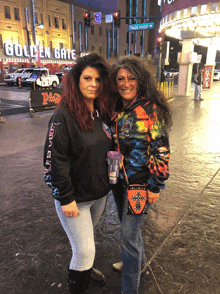 two women are posing for a picture in front of the golden gate hotel