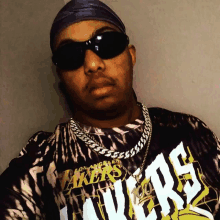 a man wearing sunglasses and a tie dye lakers shirt