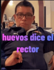 a man wearing glasses and a blue jacket has the words huevos dice el rector on his chest