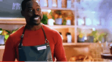 a man wearing an apron with a name tag that says george baker