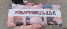 a person holding a piece of paper that says krzysiolada