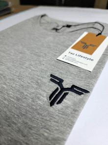 a grey shirt with a tag that says ' taz lifestyle ' on it