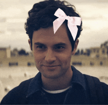 a young man with a pink bow on his head