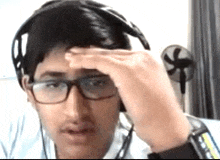 a young man wearing glasses and headphones is making a funny face