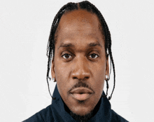 a close up of a man 's face with braids