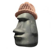 a statue of a face with a knitted hat on