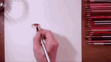 a person is drawing a person 's eye with colored pencils