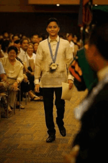 a man with a medal around his neck is walking down a runway