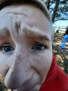 a close up of a person 's face with a red shirt around their neck