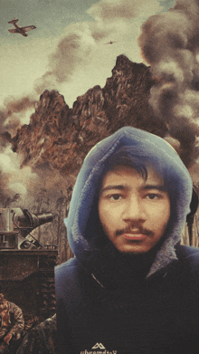 a man wearing a blue hoodie with a mountain in the background