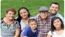 a large family is posing for a picture together in a park .