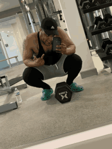 a man squatting down in front of a dumbbell that says xtbx