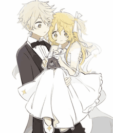 a boy in a tuxedo is holding a girl in a wedding dress