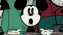 a cartoon of mickey mouse sitting in front of a laptop