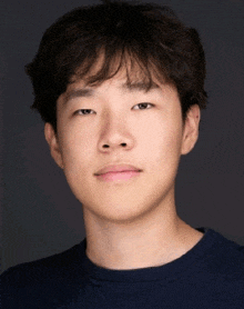 a close up of a young man 's face with a dark background