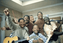 a group of men are posing for a picture with guitars .