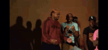 a group of men are standing in a dark room dancing .