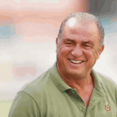a man wearing a green shirt with the letter g on the collar