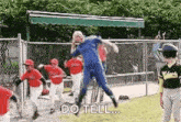 a man in a blue suit is jumping in the air while playing baseball with a group of children .