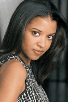 a close up of a woman 's face wearing a black and white tank top