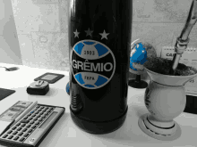 a bottle with the word gremio on it sits on a desk