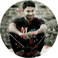 a man wearing a black shirt that says must sits in a circle of hearts