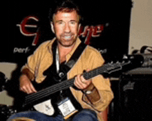 a man is playing a guitar in front of a sign that says ' george ' on it