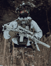 a soldier is holding a rifle with a sticker on his helmet that says " critical "