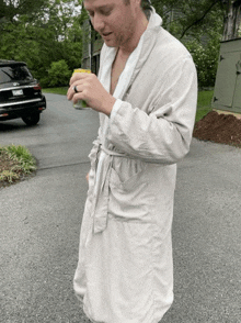 a man in a robe is holding a can of soda in his hand