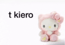 a hello kitty stuffed animal is sitting on a white surface with the words t kiero above it .