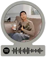 a man is sitting on a couch holding a cat and a cup