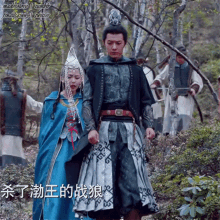 a man and a woman are walking through a forest with chinese writing