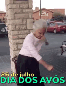 an elderly woman is dancing in front of a brick wall with the date 26 de julho dia dos avos on the bottom