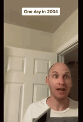 a bald man is standing in front of a door with a one day in 2004 sticker on it