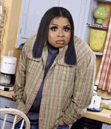 a woman in a plaid shirt is standing in front of a coffee maker