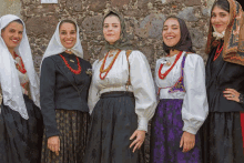 a group of women standing next to each other with one wearing a purple dress