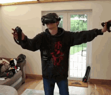 a man wearing a virtual reality headset is playing a video game in a living room