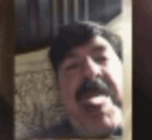 a close up of a man 's face with a mustache in a mirror .