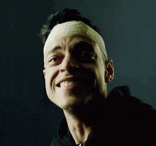 a close up of a man with a bandage on his head .