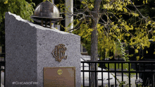 a statue of a fireman 's helmet with the number 81 on it sits on top of a granite block